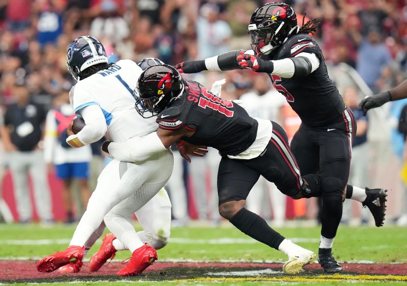 Arizona Cardinals linebackers Josh Sweat (10) and Baron Browning (5) close in for the sack on Tennessee Titans quarterback Cam Ward (1) at State Farm Stadium in Glendale on Oct. 5, 2025.
