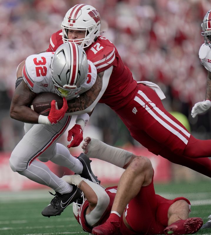 Wisconsin linebacker Nick Clayton (12) tackles Ohio State running back Isaiah West (32) during their game Oct. 18, 2025. Clayton has added almost 50 pounds since getting to campus in January 2025.