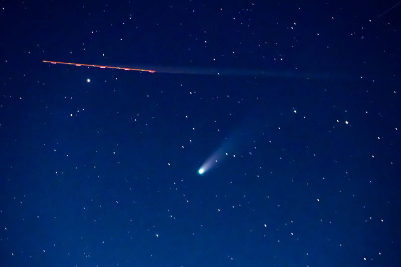 A commercial airliner crosses the Oklahoma sky as comet C/2025 A6 (Lemmon) glows faintly in the western horizon on Oct. 21, 2025 — the night of its closest approach to Earth.