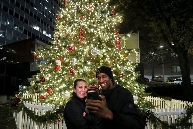 Meghan Green (left) and LeRoy Green (right) take a selfie with Valor Green, 2, during the 108th annual Christmas tree lighting ceremony Nov. 18, 2021, next to City Hall.