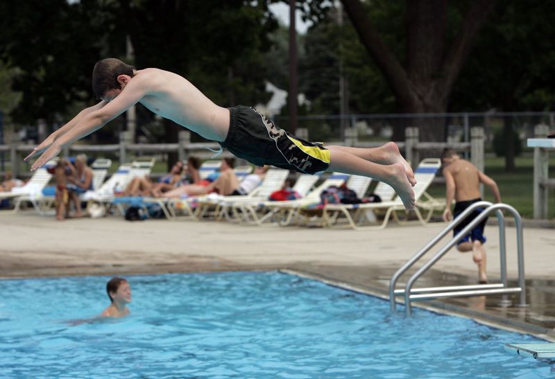 A swimmer leaves a diving board at Menasha's municipal swimming pool at Jefferson Park.