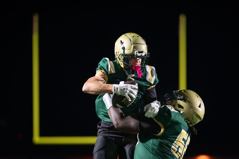 Racine Case lineman Alontae Morris (55) boosts Racine Case wide receiver Zachary DeBaker (7) in celebration of his touchdown catch in a Level 1 playoff game Friday, October 24, 2025, at Case High School in Racine, Wisconsin.