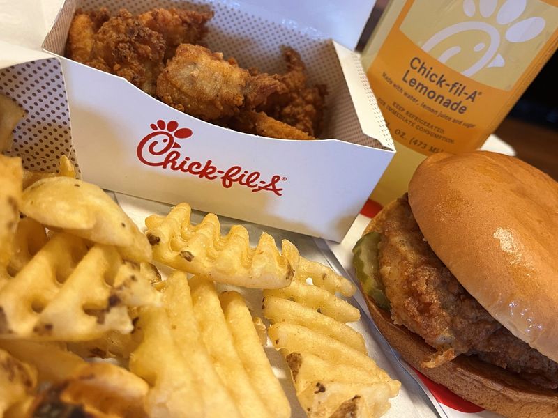 A Chick-fil-A chicken sandwich, nuggets, waffle fries and a lemonade.