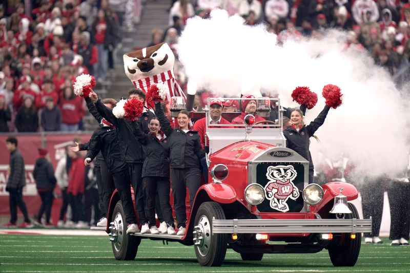 Bucky Badger rides the Bucky Wagon before the start of the Wisconsin - Washington football game Saturday, November 8, 2025 at Camp Randall Stadium in Madison, Wisconsin. The truck 1932 American LaFrance fire engine that was fitted with an electric motor in 2011 by engineering students.