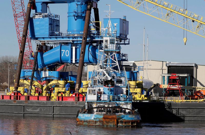 Big blue crane 70 is held against the pier at Wisconsin Heavy Fabrication as workers on cranes prepare the huge blue crane for shipping, Monday, November 17, 2025, in Manitowoc, Wis.