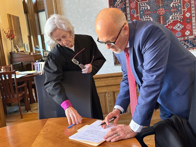 Chief U.S. District Judge Pamela Pepper observes Brad Schimel signing paperwork formalizing his appointment as interim U.S. attorney for the Eastern District of Wisconsin on Nov. 17, 2025, at the Milwaukee federal courthouse.