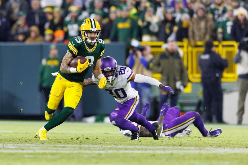 Jan 1, 2023; Green Bay, Wisconsin, USA; Green Bay Packers wide receiver Christian Watson (9) rushes with the football in front of Minnesota Vikings cornerback Duke Shelley (20) during the third quarter at Lambeau Field. Mandatory Credit: Jeff Hanisch-USA TODAY Sports