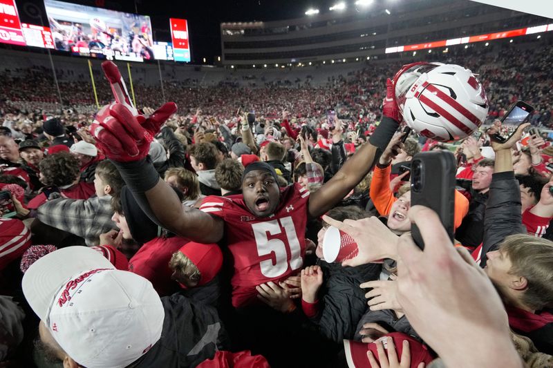 Wisconsin defensive lineman Micheal Garner (51) is swamped by fans after their game Saturday, November 22, 2025 at Camp Randall Stadium in Madison, Wisconsin. Wisconsin beat Illinois 27-10.