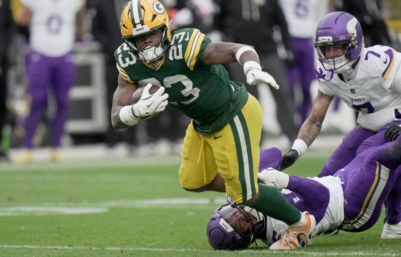 Green Bay Packers running back Emanuel Wilson (23) is tripped up during the third quarter of their game against the Minnesota Vikings Sunday, November 23, 2025 at Lambeau Field in Green Bay, Wisconsin.