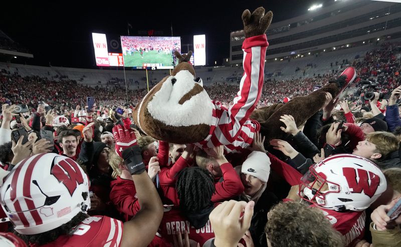 Bucky Badger crowd surfs after fans stormed the field after the Wisconsin Illinois football game Saturday, November 22, 2025 at Camp Randall Stadium in Madison, Wisconsin. Wisconsin beat Illinois 27-10.