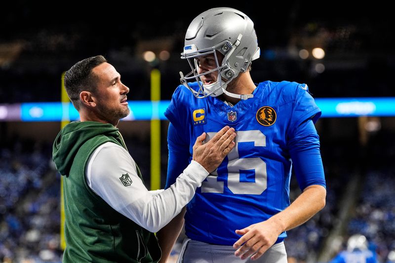 Detroit Lions quarterback Jared Goff (16), right, talk to Green Bay Packers head coach Matt LaFleur during warmup ahead of the Green Bay Packers game at Ford Field in Detroit on Thursday, Nov. 27, 2025.