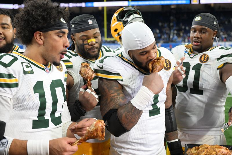 Nov 27, 2025; Detroit, Michigan, USA; Green Bay Packers quarterback Jordan Love (10), Green Bay Packers defensive end Micah Parsons (1) and Green Bay Packers defensive tackle Warren Brinson (91) eat turkey after defeating the Detroit Lions at Ford Field. Mandatory Credit: Lon Horwedel-Imagn Images