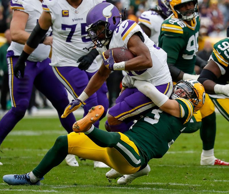 Green Bay Packers safety Evan Williams (bottom) tackles Minnesota Vikings running back Aaron Jones Sr. (top) for a loss in the game at Lambeau Field.