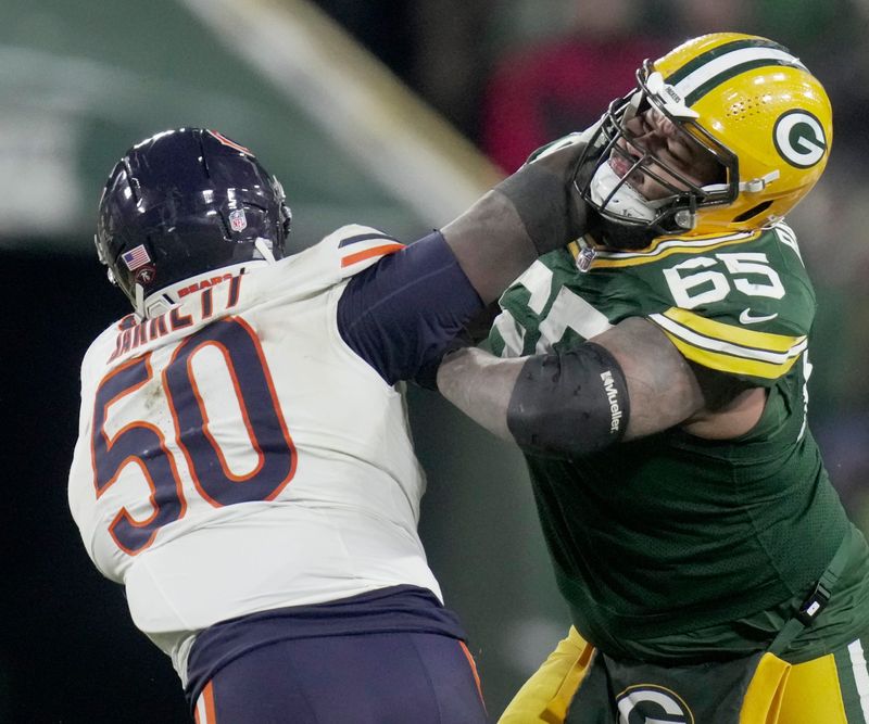 Green Bay Packers guard Aaron Banks (65) blocks Chicago Bears defensive end Grady Jarrett (50) during the fourth quarter of their game Sunday, December 7, 2025 at Lambeau Field in Green Bay, Wisconsin. The Green Bay Packers beat the Chicago Bears 28-21.