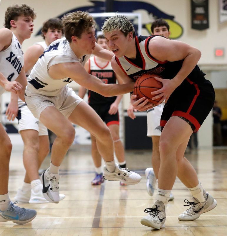 Seymour High School's Isaac Feske (32) gains control of the ball against Xavier High School's Quinn Comerford (5) during their boys basketball game Tuesday, December 9, 2025, in Appleton, Wisconsin. Seymour won 82-69.