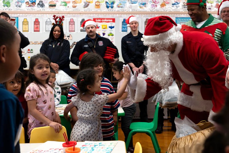 Kindergartners in Ms. Ivette’s class, Zach, 4, Allison, 4, Jesiah, 4, and Mathew, high five and thank Santa Claus for their gifts at Kagel Elementary School in Walker’s Point in Milwaukee, Wisconsin, on the morning of Dec. 11, 2025. The Daisie Foundation and the Milwaukee Fire Department teamed up for the Holiday Magic Express to surprise students with holiday gifts and a free lunch.