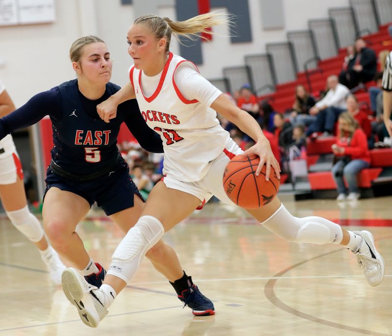 Neenah High School's Rowan Klesmit (11) drives to the basket against Appleton East High School's Ambria Fischer (5) during their girls basketball game Tuesday, December 23, 2025, at Neenah High School in Fox Crossing, Wisconsin. Appleton East won 81-71.