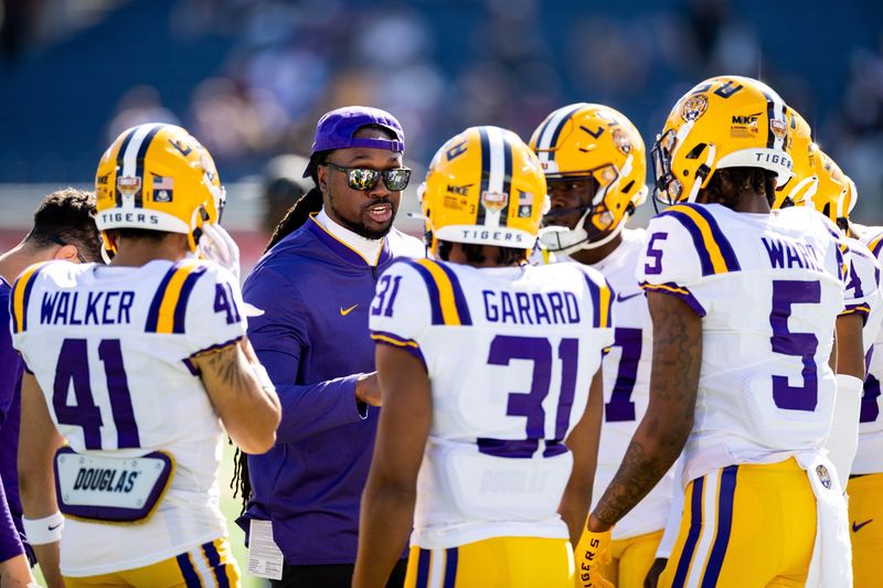 Jan 2, 2023; Orlando, FL, USA; LSU Tigers cornerbacks coach Robert Steeples talks with cornerback Ralph Walker (41), cornerback Everett Garard (31), and safety Jay Ward (5) before the game against the Purdue Boilermakers at Camping World Stadium. Mandatory Credit: Matt Pendleton-USA TODAY Sports
