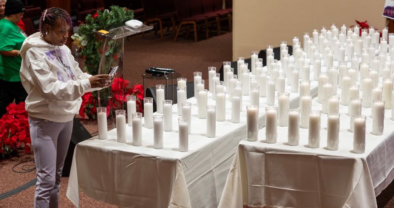 Nina Harris makes a photo of the 160 candles in memory of the city’s homicide victims at the Milwaukee 2025 “Forever In Our Hearts” Homicide Candlelight Vigil Sunday, December 28, 2025 at Ephesians Missionary Baptist Church, 2412 N. 6th St. in Milwaukee, Wisconsin. Her son, Antwuan Lucas was a murder victim.