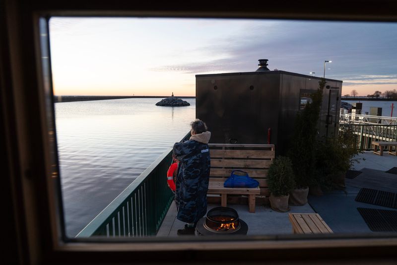 Jennifer Bartolotta looks out Lake Michigan before her sunrise session Hot Spell Sauna at McKinley Marina in Milwaukee, Wisconsin, on the morning of Nov. 23, 2025.