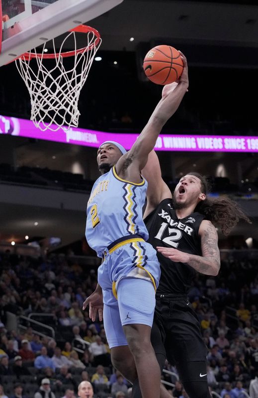 Marquette guard Chase Ross (2) dunks the ball on Xavier forward Tre Carroll (12) during the first half of their game Wednesday, January 7, 2026 at Fiserv Forum in Milwaukee, Wisconsin.