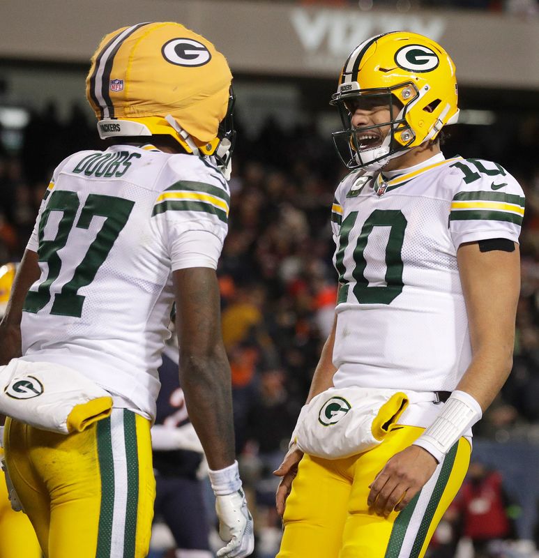 Green Bay Packers quarterback Jordan Love and wide receiver Romeo Doubs celebrate a touchdown against the Chicago Bears during their wild-card playoff game.