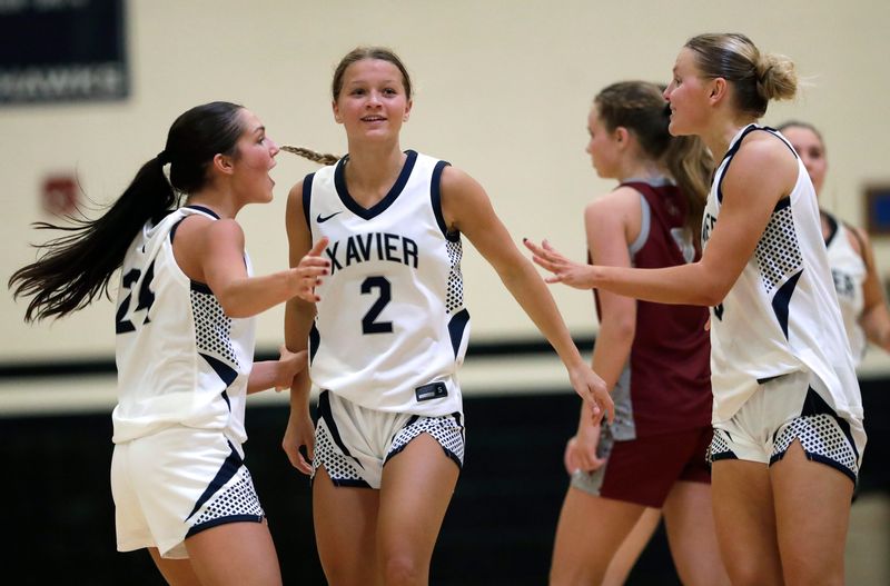 Xavier High School players celebrate their victory against Winneconne High School during their girls basketball game Tuesday, January 13, 2026, in Appleton, Wisconsin. Xavier won 53-46.