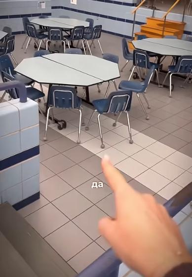 Screenshot from a viral YouTube video titled "Where do popular girls sit during lunch in US schools," shot inside the cafeteria of Carl Traeger Middle School in Oshkosh, Wisconsin.