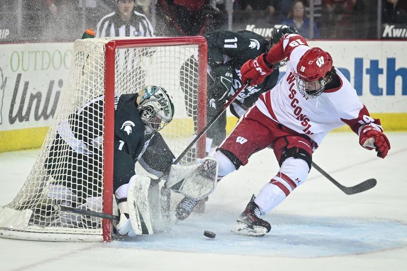 Wisconsin left wing Quinn Finley (19) slides into Michigan State goaltender Trey Augustine (1) while trying to score on a breakaway in a game Thursday, January 15, 2026, at the Kohl Center in Madison, Wisconsin.