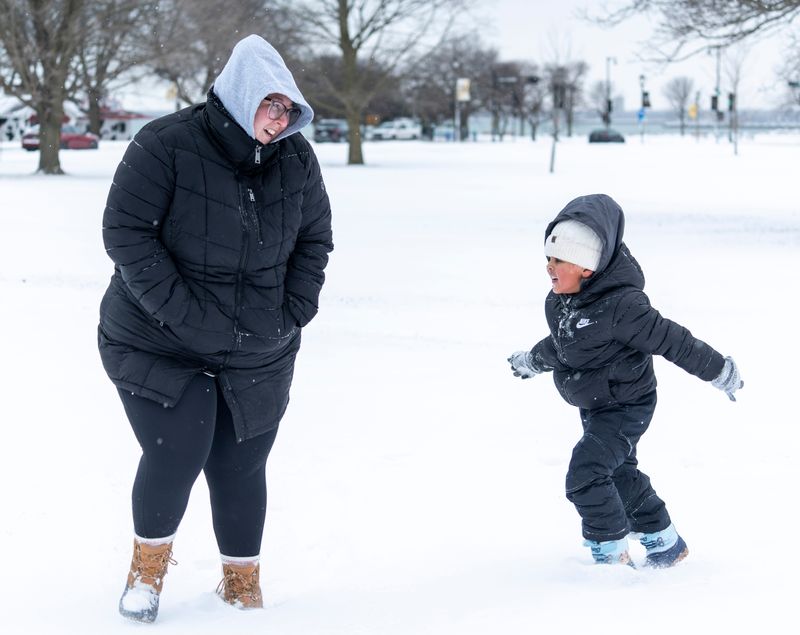 Jessica Guiro plays in the snow with 4-year-old Abdoul Guiro near Bradford Beach on Saturday January 17, 2026 in Milwaukee, Wisconsin.