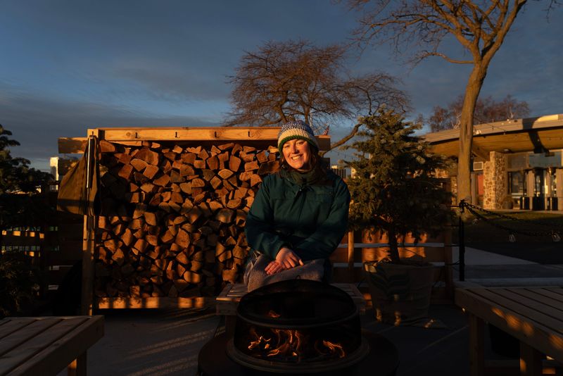 Milwaukee Journal Sentinel reporter Bridget Fogarty sits by the fire before a sunrise sauna session Nov. 23 at Hot Spell, located at McKinley Marina in Milwaukee.