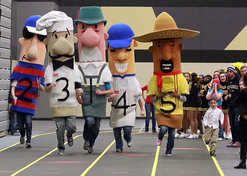 A youngster tries to keep up with the Milwaukee Brewers Racing Sausages as they race along an indoor track following the dedication of Brown Deer High School’s Novak Family Field House on April 10, 2013.