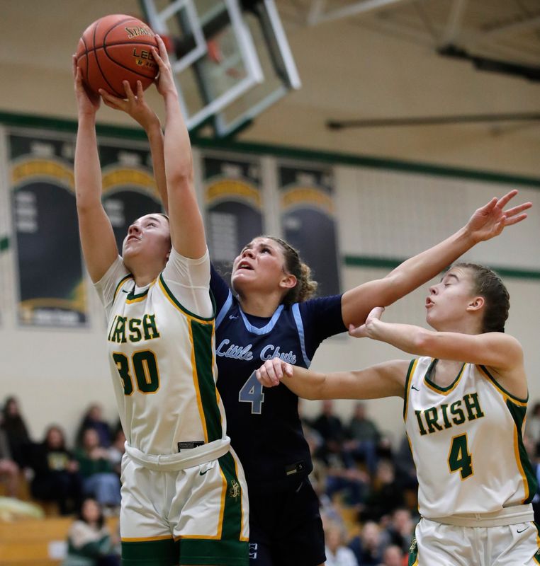 Little Chute High School's Elliana Martin (4) battles for a rebound against Freedom High School’s Khloe VandenBerg (30) and Brooke Sowinski (4) during their girls basketball game Tuesday, February 10, 2026, in Freedom. Little Chute won 52-36.
