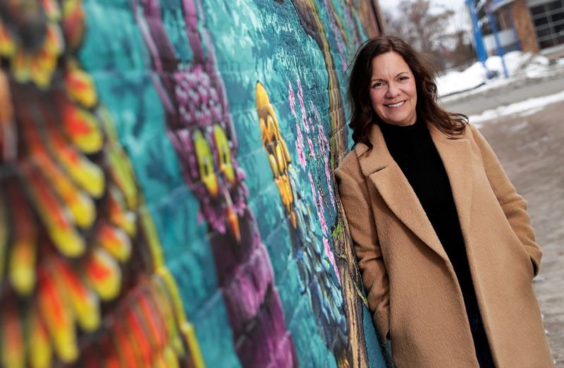 Tina Quigley, executive director of Definitely De Pere, poses for a portrait in front of The Owl Tree mural near the Urban Forest Walkway on Feb. 10, 2026, in De Pere.
