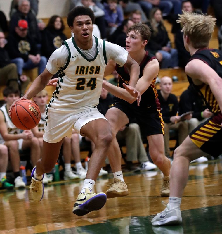 Freedom High School's Donovan Davis (24) drives to the basket against Luxemburg-Casco High School's Mason Trimberger (12) and Tatem Klaubauf (1) during their boys basketball game Thursday, February 12, 2026, in Freedom. Freedom won 89-48.