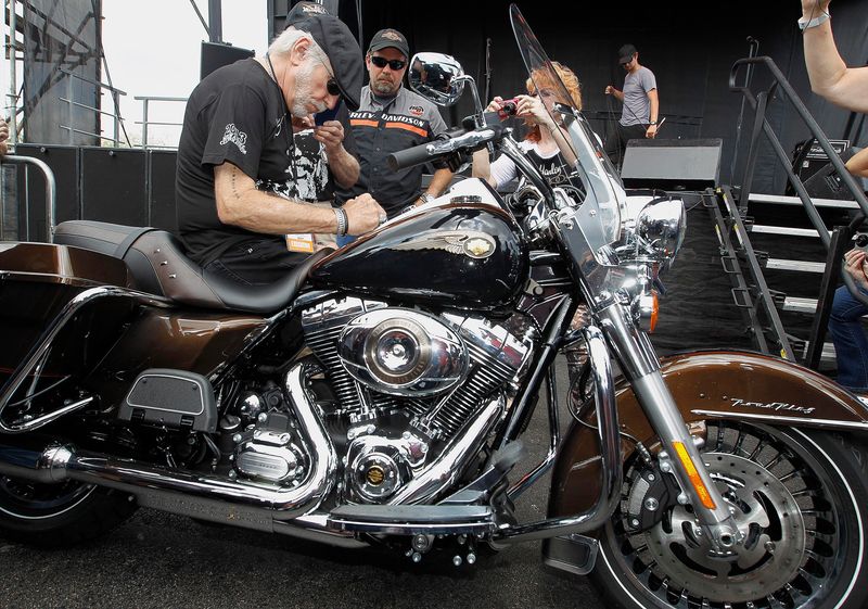Willie G. Davidson autographs a new Limited Edition 110th Anniversary Road King given to Terry Allan Carlton and his wife Nancy as winners in the Freedom for Keeps Membership sweepstakes. The keys were given to the couple at the Harley Davidson museum on September 1, 2013, during the Harley Davidson Custom Bike Show at the Museum.