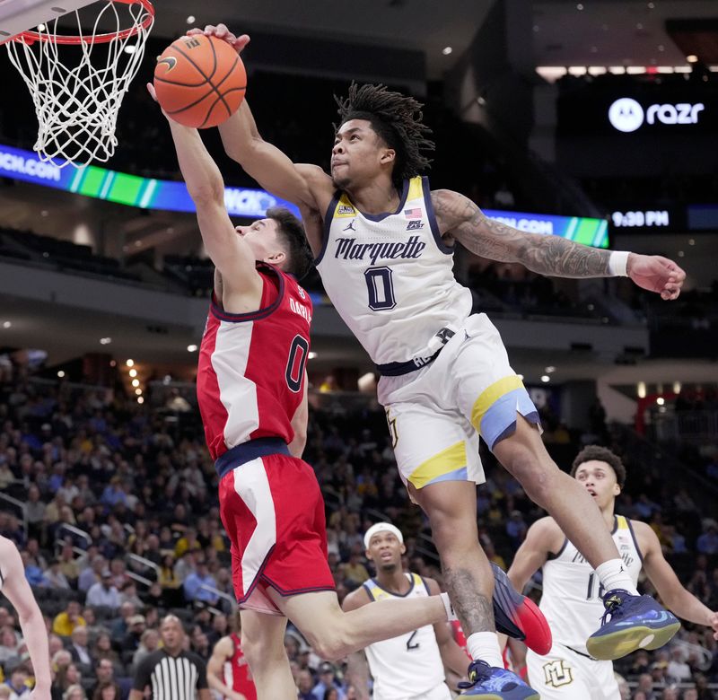 Marquette guard Nigel James Jr. (0) blocks a shot by St. John's guard Dylan Darling (0) during the second half of their game Wednesday, February 18, 2026 at Fiserv Forum in Milwaukee, Wisconsin. St. John’s beat Marquette 76-70.