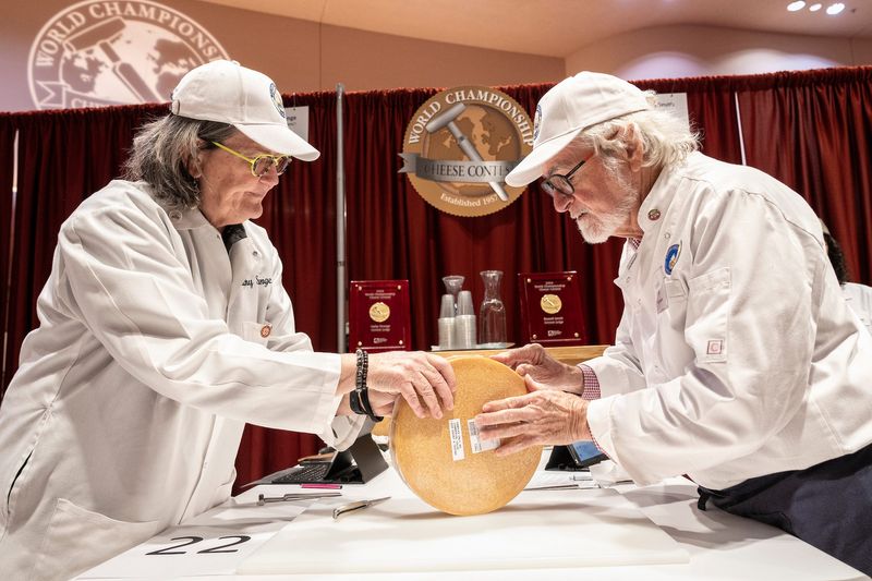 Judges Cathy Strange of Whole Foods Market (left) and Russell Smith of Dairy Australia evaluate an entry at the 2024 World Championship Cheese Contest.
