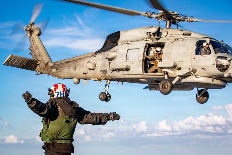A U.S. Sailor signals the launch of an MH-60R Sea Hawk helicopter, attached to Helicopter Maritime Strike Squadron 70, on the flight deck of the world's largest aircraft carrier, USS Gerald R. Ford (CVN 78), while supporting Operation Epic Fury on Feb. 28, 2026.