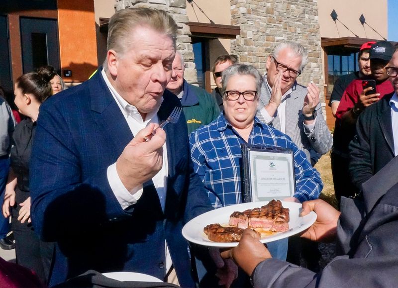 Town Chairman of the Town of Sheboygan Dan Hein bites into the first steak during the opening of the LongHorn Steakhouse, Monday, March 2, 2026, in Sheboygan, Wis.