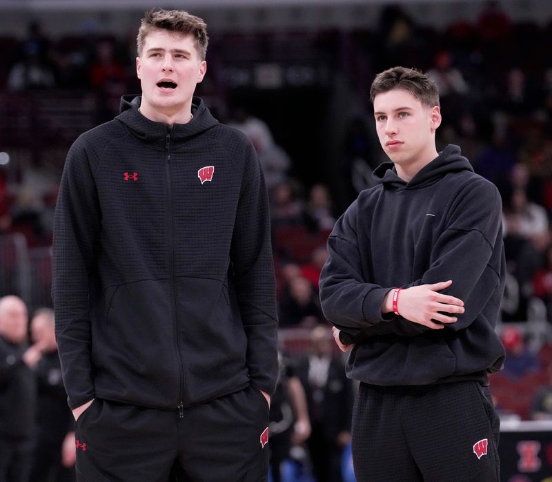 Injured Wisconsin forward Nolan Winter, left, talks with injured guard Jack Janicki before the second half of their third round game of the Big Ten tournament Thursday, March 12, 2026 at the United Center in Chicago, Illinois. Wisconsin beat Washington 85-82.