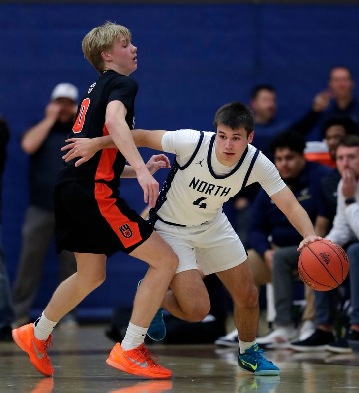 Appleton North's Nathan Ramus (4) gets past Kaukauna's Tyler Schwalbach (0) during their Fox Valley Association boys basketball game December 16 in Appleton. Kaukauna won 60-59 on a last-second shot by Andrew Jensen.