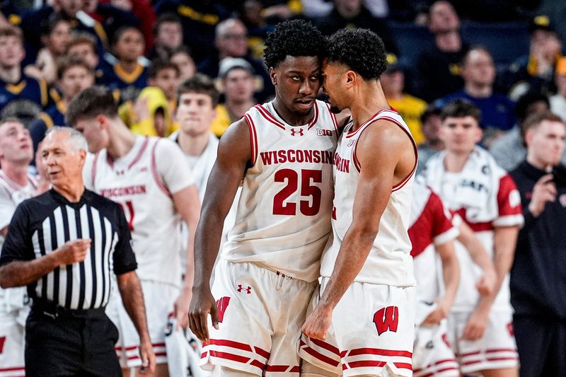 Wisconsin guard John Blackwell (25) and guard Nick Boyd (2) celebrate an upset of the Michigan Wolverines in an NCAA basketball game on on Saturday, Jan. 10, 2026, at Crisler Center in Ann Arbor, Michigan.