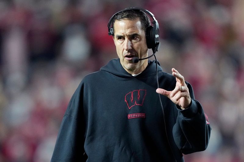 Nov 22, 2025; Madison, Wisconsin, USA; Wisconsin Badgers head coach Luke Fickell talks to his team during the second half against the Illinois Fighting Illini at Camp Randall Stadium. Mandatory Credit: Kayla Wolf-Imagn Images