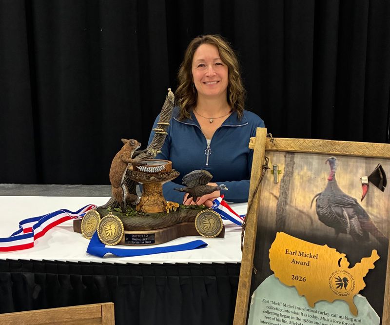 Heather van Doorn of Glen Flora, Wis. poses with "Outfoxed," the turkey call she designed and carved that won the Earl Mickel Award for the best decorative turkey call at the 2026 National Wild Turkey Federation convention.