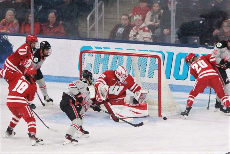 Wisconsin goaltender Ava McNaughton and defender Vivian Jungels (20) attempt to control the puck after an Ohio State shot during the Badgers' 3-2 victory over Ohio State in the national championship game March 22, 2026, at Pegula Ice Arena.