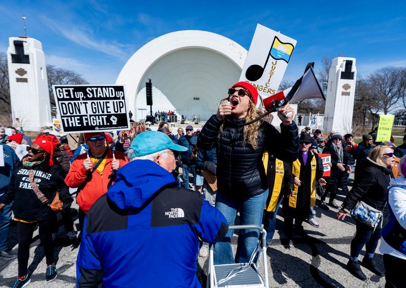 Desiree Pointer Mace of the Milwaukee Justice Singers, center, leads a crowd in song as they participate in a third wave of “No Kings” protests against President Donald Trump’s administration at the Washington Park Bandshell on March 28, 2026, in Milwaukee, Wisconsin.