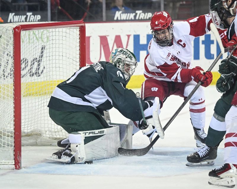 Michigan State goaltender Trey Augustine (1) blocks a shot by Wisconsin defenseman Ben Dexheimer (4) in a game Thursday, January 15, 2026, at the Kohl Center in Madison, Wisconsin.