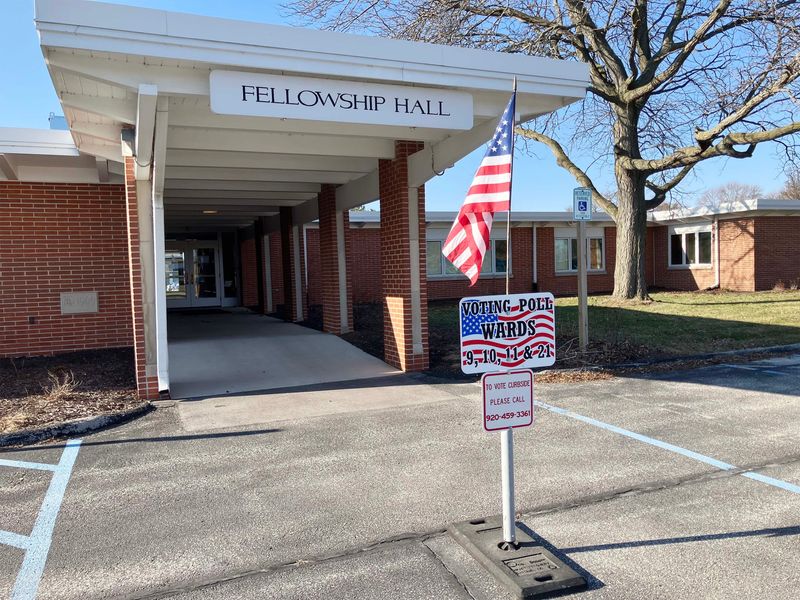 The fellowship hall entrance to First United Church also features a voting poll sign as seen, Tuesday, April 7, 2026, in Sheboygan, Wis.