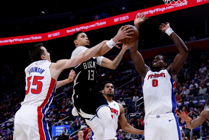 Bucks guard Ryan Rollins goes up for two of his team-high 23 points against Pistons center Jalen Duren (0) and forward Duncan Robinson (55) in the first half on Wednesday, April 8 at Little Caesars Arena in Detroit.